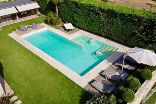 an overhead view of a swimming pool with chairs and an umbrella at Luxury Floor Apartment with Private Pool in Drafí