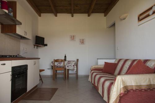 a kitchen and a living room with a couch and a table at Roccabianca in Sorso