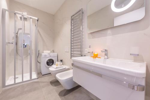 La salle de bains est pourvue d'un lavabo, de toilettes et d'une douche. dans l'établissement Heart of Lugano - Happy Rentals, à Lugano
