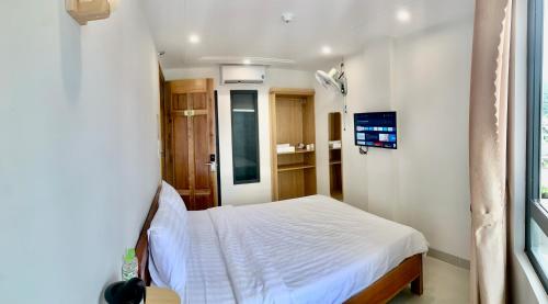 een slaapkamer met een wit bed in een kamer bij KHÁCH SẠN GIA HÒA 3 in Vung Tau