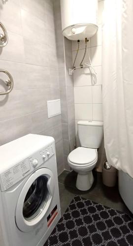 La salle de bains est pourvue d'un lave-linge et de toilettes. dans l'établissement Просторная квартира студия ЮЖД 5 минут, à Kharkov