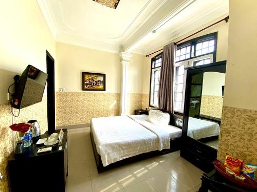 - une chambre d'hôtel avec un lit et un miroir dans l'établissement Jade Hotel, à Hue