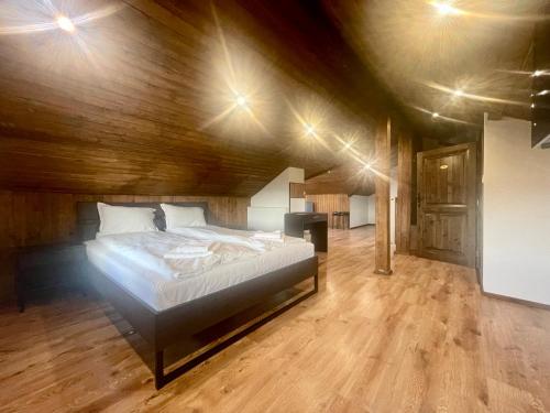 een slaapkamer met een groot bed in een houten plafond bij Къща за гости Алида in Sapareva Banya