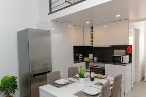 a kitchen with a table and chairs and a refrigerator at Antiga adega in Óbidos