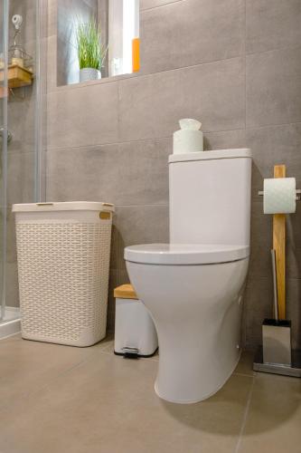 a bathroom with a toilet and a trash can at Antiga adega in Óbidos