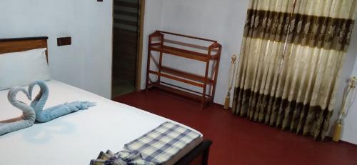 a bedroom with a bed and a chair in it at Peacock Residence & Cabana's in Tangalle