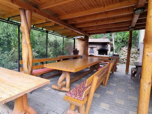 un patio con tavoli e panche in legno e stufa di family cottage a Senica