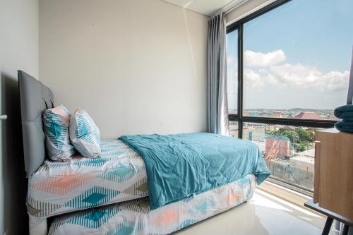 a bedroom with a bed and a large window at Palam Mansion at Apartment One Residence in Batam Center