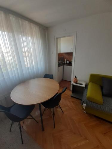 a living room with a table and chairs and a couch at Centar apartman - gradski trg in Gornji Milanovac