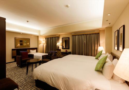 a hotel room with a large bed and a living room at Kanazawa New Grand Hotel Prestige in Kanazawa