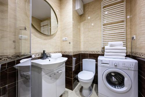 a bathroom with a toilet sink and a washing machine at Native Apartments Poznańska 7 in Krakow