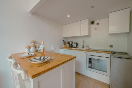 une cuisine avec des armoires blanches et un comptoir en bois dans l'établissement Résidence Grand Roc - Campanules 103 - Happy Rentals, à Chamonix-Mont-Blanc