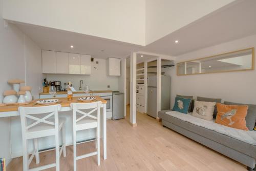 une cuisine et un salon avec un canapé et une table dans l'établissement Résidence Grand Roc - Campanules 103 - Happy Rentals, à Chamonix-Mont-Blanc