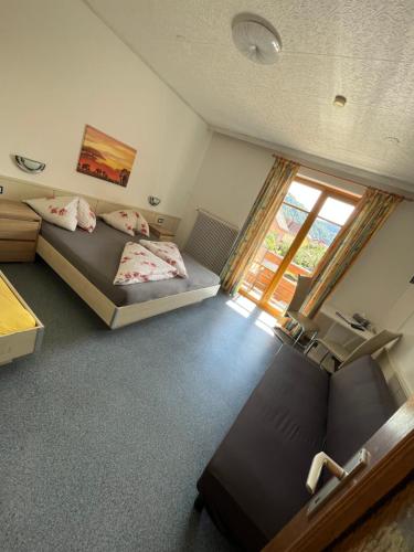 una camera da letto con due letti e una finestra di Pension Lärchenhof a Döbriach
