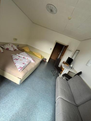 a bedroom with a bed and a couch in it at Pension Lärchenhof in Döbriach