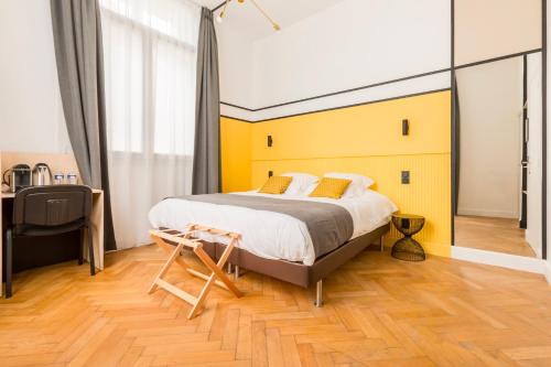 um quarto com uma cama grande e uma parede amarela em Le Chat Qui Dort - Villa Gounod em Lille