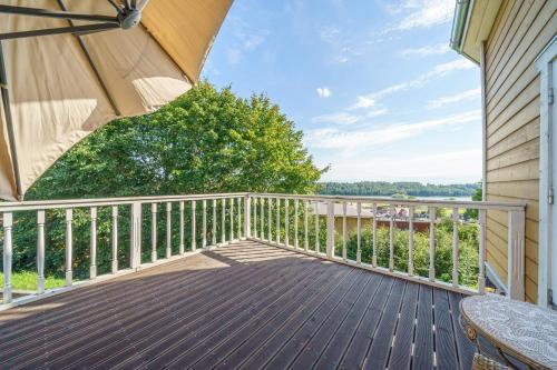 a balcony with a table and an umbrella at Apartment With a Lake View and Sauna in Viljandi