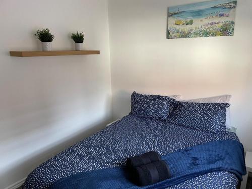 a bedroom with a bed with a blue comforter at May Disc - Long Stay - Contractors in Bristol