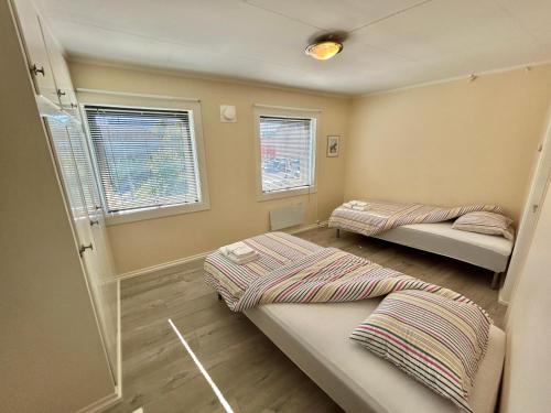 dwa łóżka w pokoju z dwoma oknami w obiekcie Gjestehuset Borggata 18 w mieście Fredrikstad