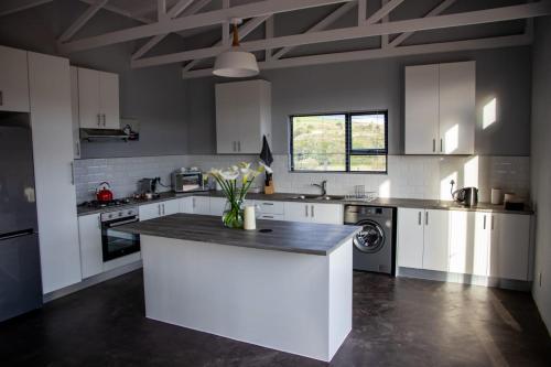 a kitchen with white cabinets and a counter with flowers on it at House on the Hill in Heidelberg