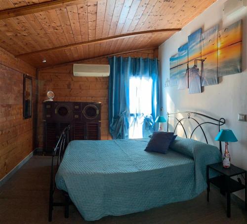 1 dormitorio con cama con colcha azul y ventana en Affittacamere MADE IN PISA Locazione Turistica, en Pisa