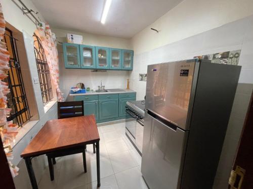 a kitchen with blue cabinets and a table and a refrigerator at Nyari estate in Nairobi