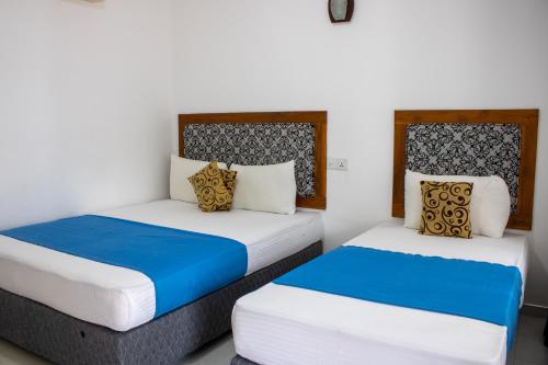 two beds sitting next to each other in a room at National Holiday Resort in Mahiyangana