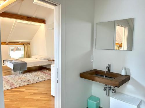 1 dormitorio con 1 cama y baño con lavabo. en Historic Rooms and Apartments in the City Centre of Bolzano, en Bolzano