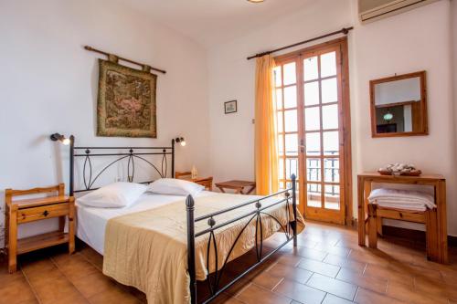 een slaapkamer met een bed, een spiegel en een raam bij Villa Diamanti in Monemvasia