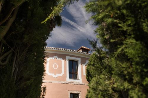 a pink building with a window on top of it at Castilla Termal Brihuega in Brihuega