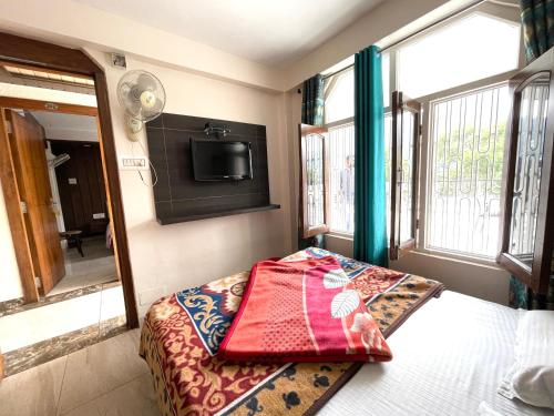 um quarto com uma cama e uma televisão na parede em HOTEL PRINCE ! NAINITAL Mall Road-prime-location in-front-of-Naini-lake hygiene-and-spacious-room em Nainital