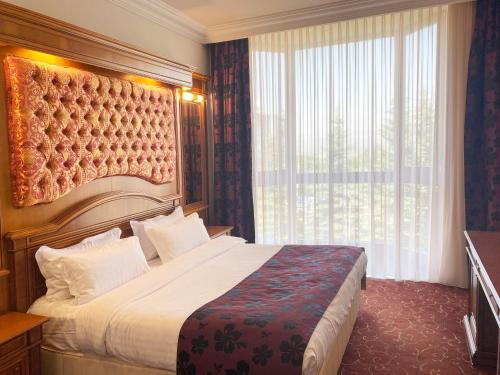 Habitación de hotel con cama y ventana grande en Hotel Russia, en Tsaghkadzor