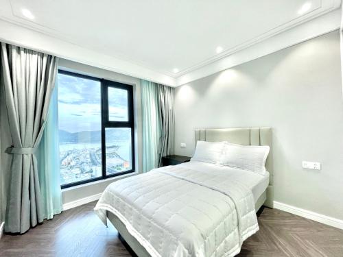 um quarto com uma cama e uma grande janela em Căn hộ view biển cao cấp Altara em Quy Nhon