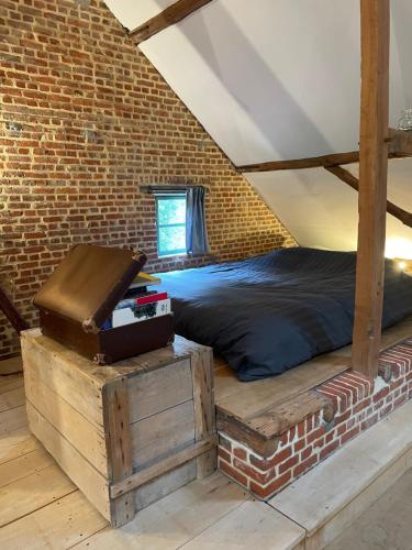 1 dormitorio con cama y pared de ladrillo en Art Of Einstein en Diest