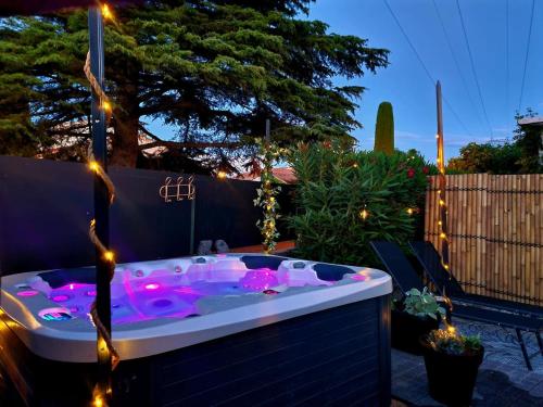 a hot tub with lights in a backyard at night at La pause en luberon in Cavaillon