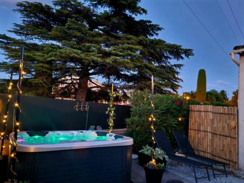 a hot tub in a backyard with a tree at La pause en luberon in Cavaillon