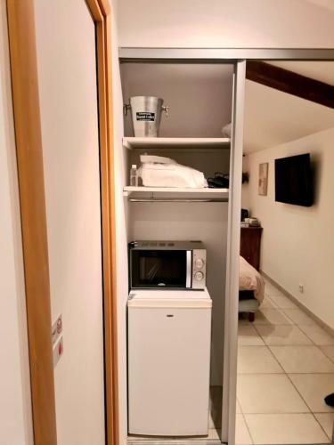 a small kitchen with a microwave on top of a refrigerator at La pause en luberon in Cavaillon