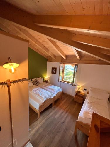 1 dormitorio con 2 camas en una habitación con techos de madera en Agritur Maso Val Fraja, en Cembra