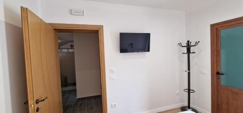Habitación con TV en la pared y puerta en Kutal Parkinn Hotel en Përmet