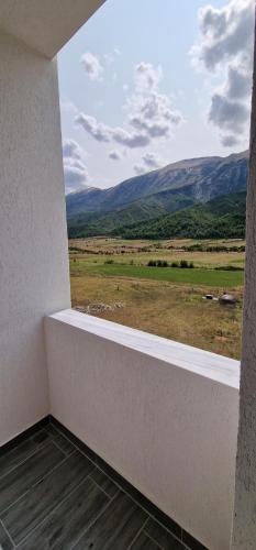 a room with a window with a view of a field at Kutal Park Inn Hotel in Përmet