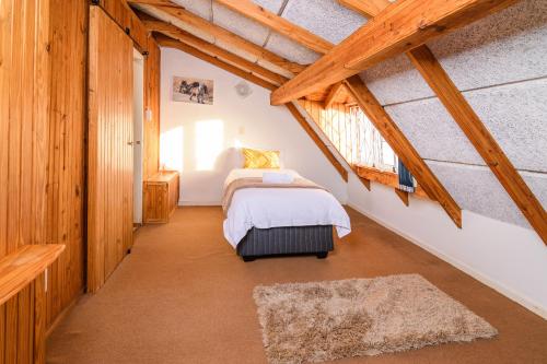 a attic bedroom with a bed and a window at Zi Wu Self Catering Apartment in Swakopmund