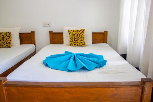 a bed with a blue bow on it at National Holiday Resort in Mahiyangana