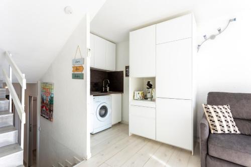 un salon avec un escalier et un lave-linge dans l'établissement T2 Duplex climatisé à 5min de la plage, au Grau-du-Roi