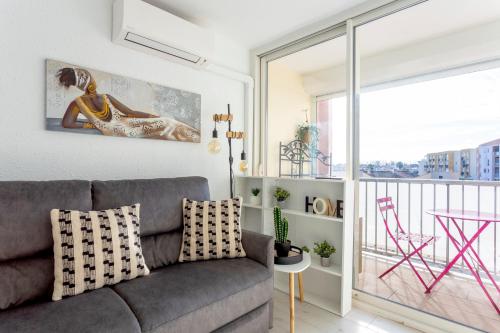 d'un salon avec un canapé et un balcon. dans l'établissement T2 Duplex climatisé à 5min de la plage, au Grau-du-Roi