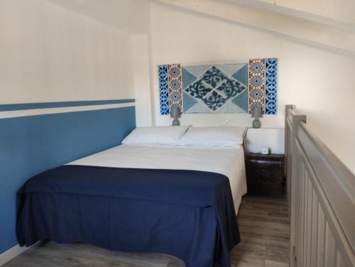 een slaapkamer met een bed met blauwe en witte lakens bij B&B La Dolce Riva in Lugo