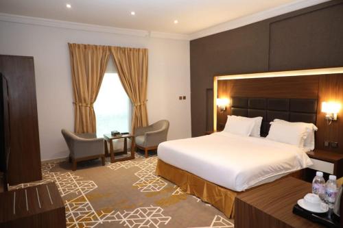 a hotel room with a large bed and a desk at Taj Al-Wajh Hotel in Al Wajh