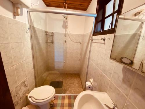 uma casa de banho com um chuveiro, um WC e um lavatório. em Pousada Cantinho da Montanha em Visconde de Mauá