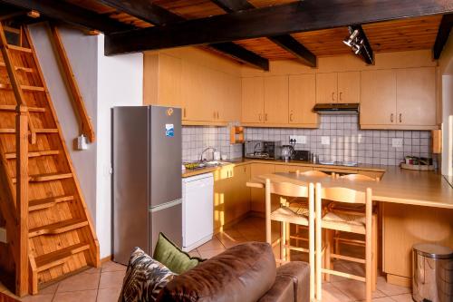 a kitchen with a refrigerator and a table and chairs at Zi Wu Self Catering Apartment in Swakopmund