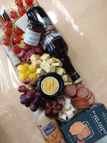 a plate of food with a bottle of wine and cheese at Chalet Conference 6 pers. in Hengstdijk