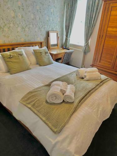 a bedroom with a bed with towels on it at A charming luxury apartment! in Portinscale